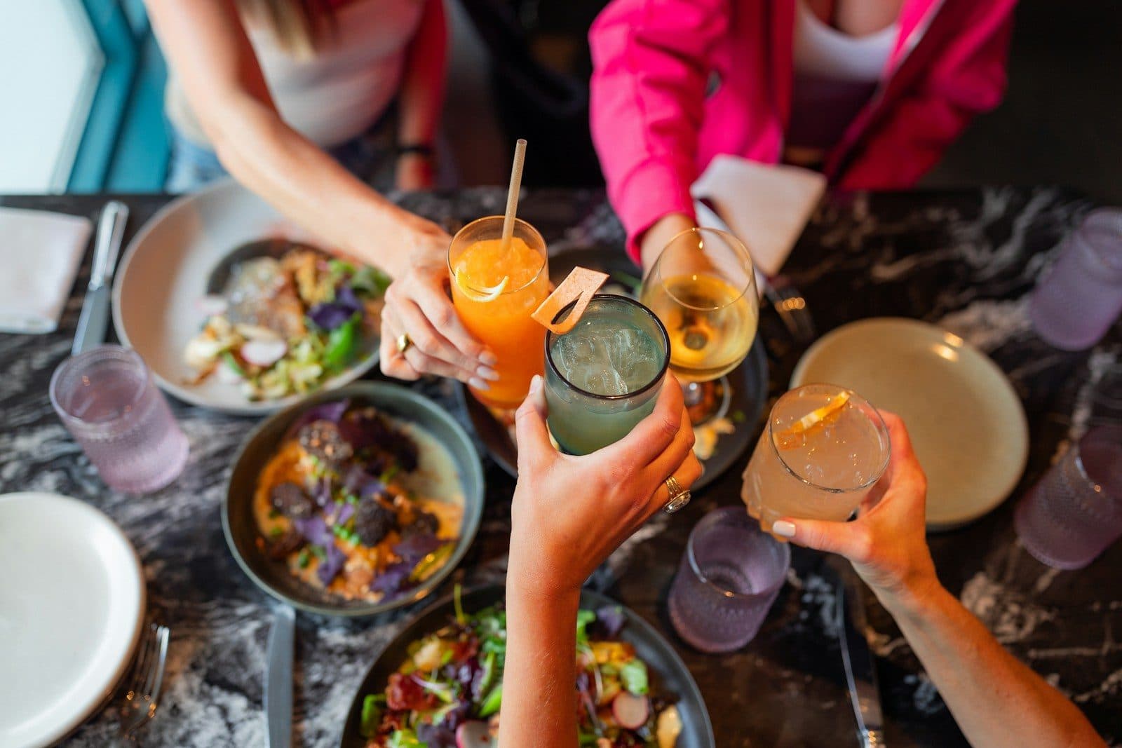 Friends raising their glasses over a shared brunch table